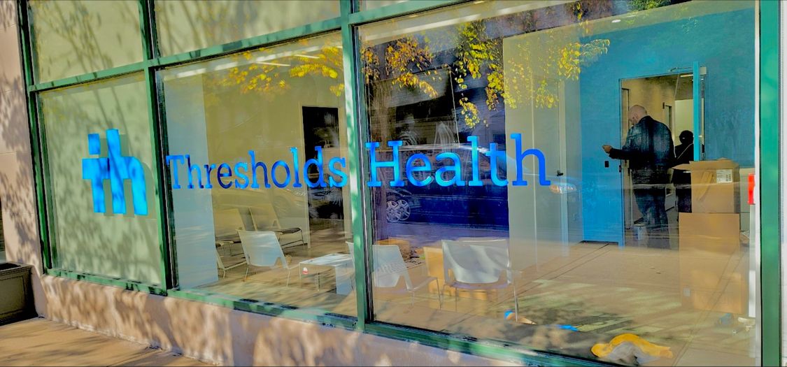 Thresholds Health signage on window