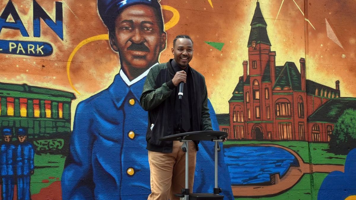 Artist Joe Cujo Nelson speaks at the unveiling of his Pullman Porters mural