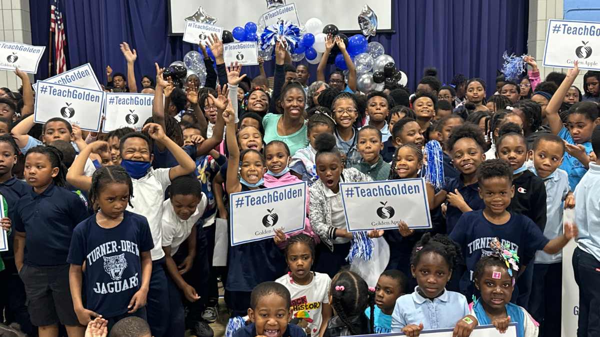 Turner Drew Language Academy students celebrates teacher Alicia Carlisle's Golden Apple Award.