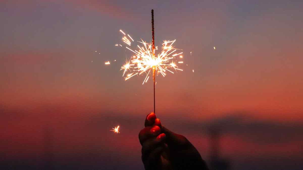 Image of a hand holding a sparkler for July 4th Fireworks safety