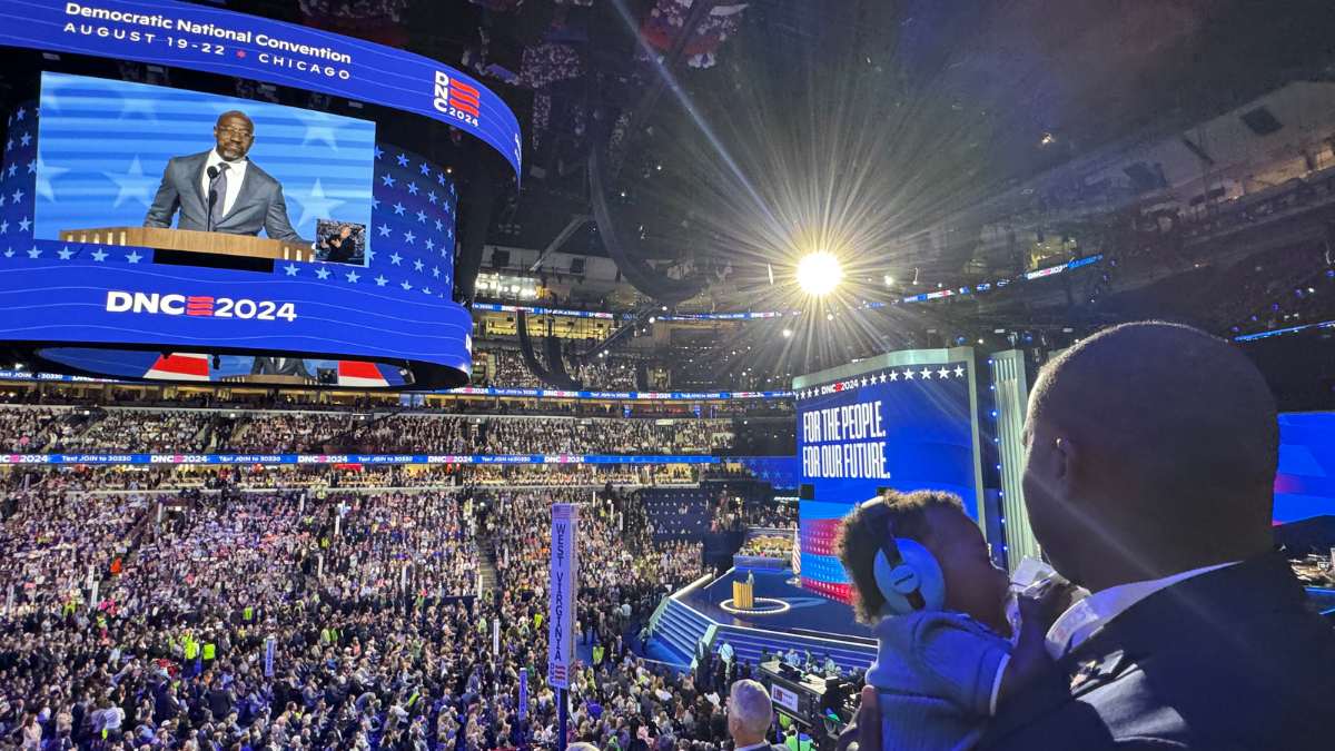 Kouri Marshall at the DNC at the United Center watching Rev. Raphael Warnock speak with his son